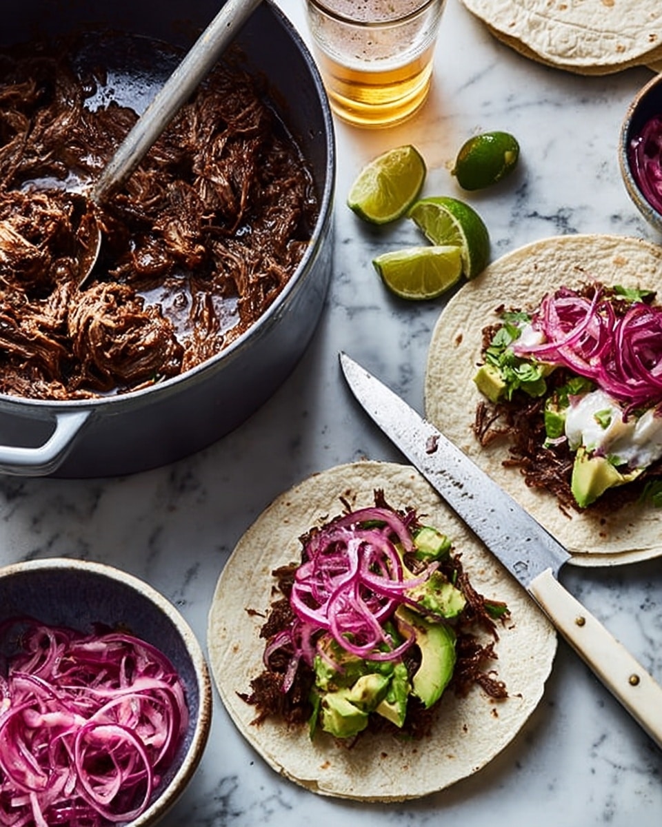A close-up view shows two white soft tortillas on a white marbled surface, each topped with three layers: the first is dark brown shredded meat, the second is bright green chunks of avocado, and the third is thin, curly slices of purple pickled onions spread on top. Next to the tortillas is a small white bowl filled with more purple pickled onions. A large gray pot filled with the dark brown shredded meat sits nearby with a large metal spoon inside. A lime wedge is placed near each tortilla, and there is a glass of light beer in the background. A woman's hand is holding a large knife with a white handle next to the tortillas. The surface underneath is a white marbled texture. photo taken with an iphone --ar 4:5 --v 7