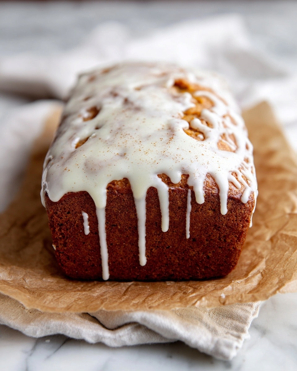A loaf of golden brown cake with a rough texture sits on a wooden board, covered with a thick layer of white icing that drips down the sides in uneven lines. Next to the cake, a silver knife with ornate details rests on a red and white checkered cloth. In the background, a clear glass of milk is slightly blurred, all placed on a white marbled surface photo taken with an iphone --ar 4:5 --v 7