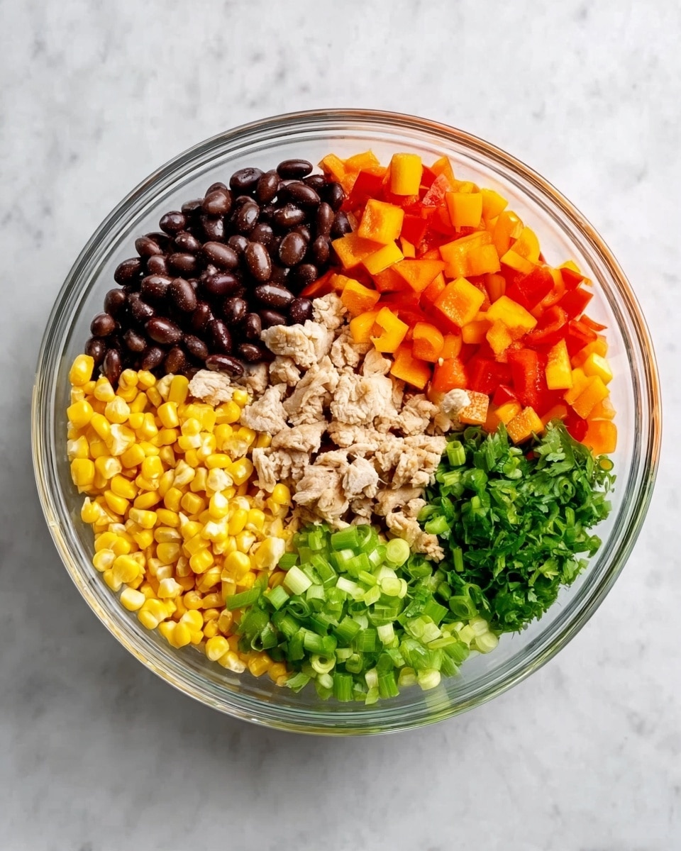 A clear glass bowl holds five main layers of ingredients, each sectioned neatly. Starting from the top left, there are dark brown beans with a smooth texture. To the right of the beans are small, bright orange diced bell peppers with a shiny surface. Below the peppers, there are small, beige pieces of what looks like cooked chicken with a soft and flaky texture. To the lower right of the bowl is a pile of chopped green onions, fresh and crisp. Finally, at the bottom left, there is a layer of yellow sweet corn kernels, smooth and glossy. The bowl is placed on a white marbled surface. Photo taken with an iphone --ar 4:5 --v 7