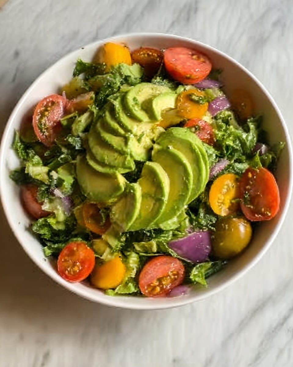 The image shows a white marbled table with two bowls filled with green salad. One bowl is medium-sized and transparent, filled with chopped kale and small cubes of yellow cheese or fruit. The other bowl is smaller and orange, also filled with the same kale and yellow cubes. On the table near the bowls are two halved oranges, an avocado half without the seed, and a clear glass jar holding a yellow dressing with visible seeds. Two black-handled knives are positioned on the table, one near the oranges and one near the avocado, adding to the organized and fresh food preparation scene. Photo taken with an iphone --ar 4:5 --v 7
