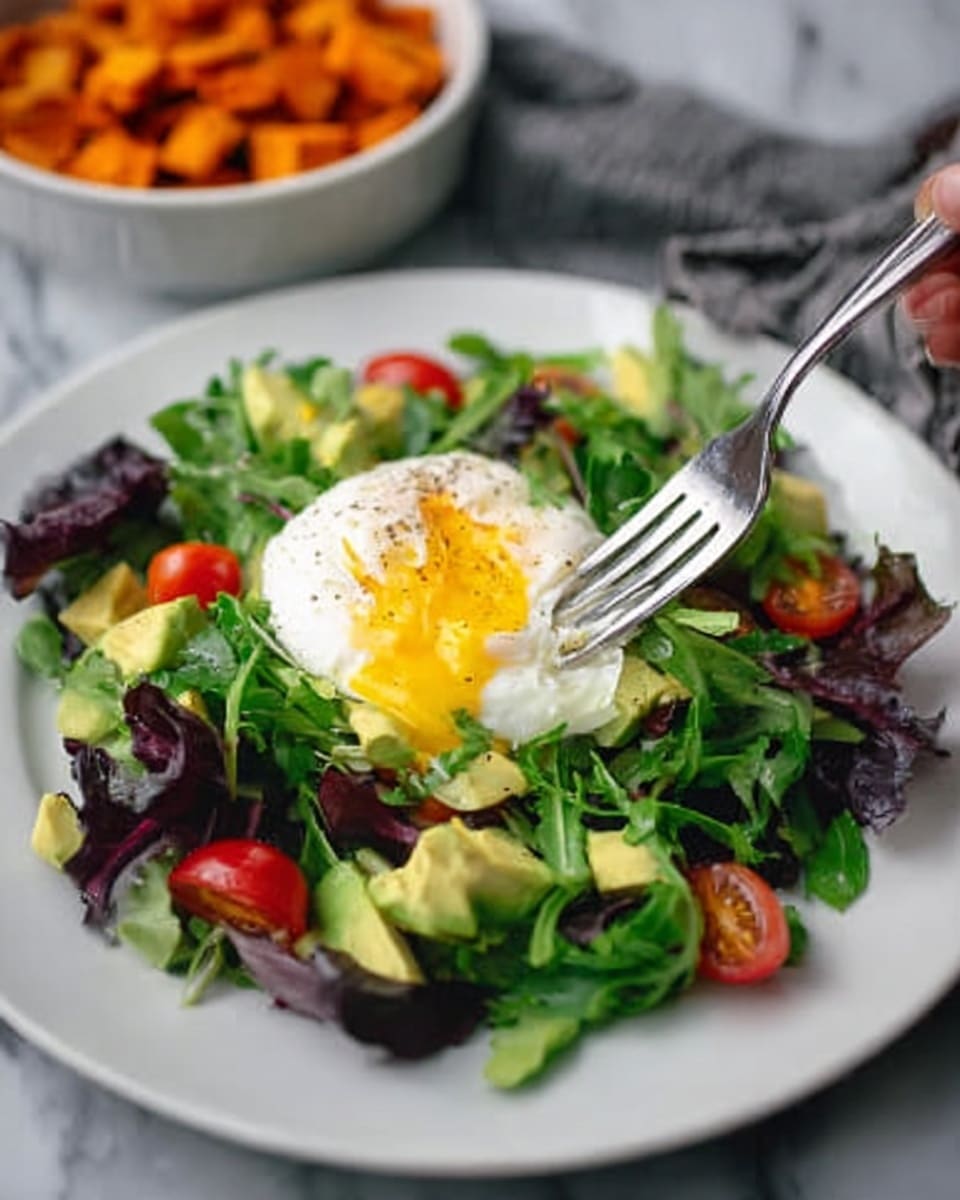A white plate with a salad made of mixed green leaves as the base layer, showing different shades of green and purple. On top, there are small pieces of red cherry tomatoes and diced pale yellow avocado scattered evenly. At the center of the plate, a single poached egg sits with a soft white outer layer and a bright yellow yolk slightly oozing out. A woman's hand is holding a silver fork poised to take a bite. The plate is placed on a white marbled surface, and the blurred background shows a white bowl filled with diced orange sweet potatoes. Photo taken with an iphone --ar 4:5 --v 7