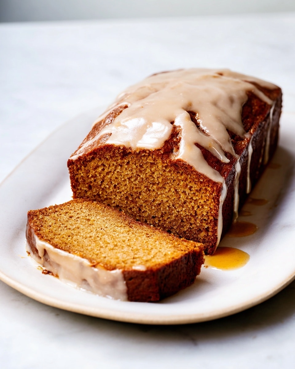 The image shows five thick slices of a yellow-orange loaf cake arranged in a neat row on parchment paper. Each slice has a smooth white glaze layer on top that shines gently, contrasting with the moist and slightly crumbly texture of the cake below. The edges of the cake are lightly browned, adding a subtle roughness to the otherwise soft look. The parchment paper lies on a white marbled surface, and to the left, there is a knife with traces of the cake next to it. Photo taken with an iphone --ar 4:5 --v 7