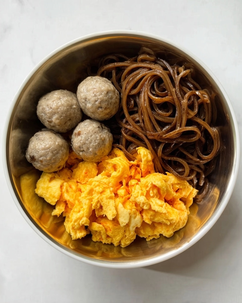 A white bowl filled with three layers is shown on a white marbled surface. At the bottom, there is a base layer of dark brown noodles that are slightly glossy and twisted together. On the right side, a scrambled egg layer with a bright yellow color and soft, fluffy texture sits beside the noodles. On the left side, three round grayish-brown meatballs are arranged neatly, looking smooth and cooked. photo taken with an iphone --ar 4:5 --v 7