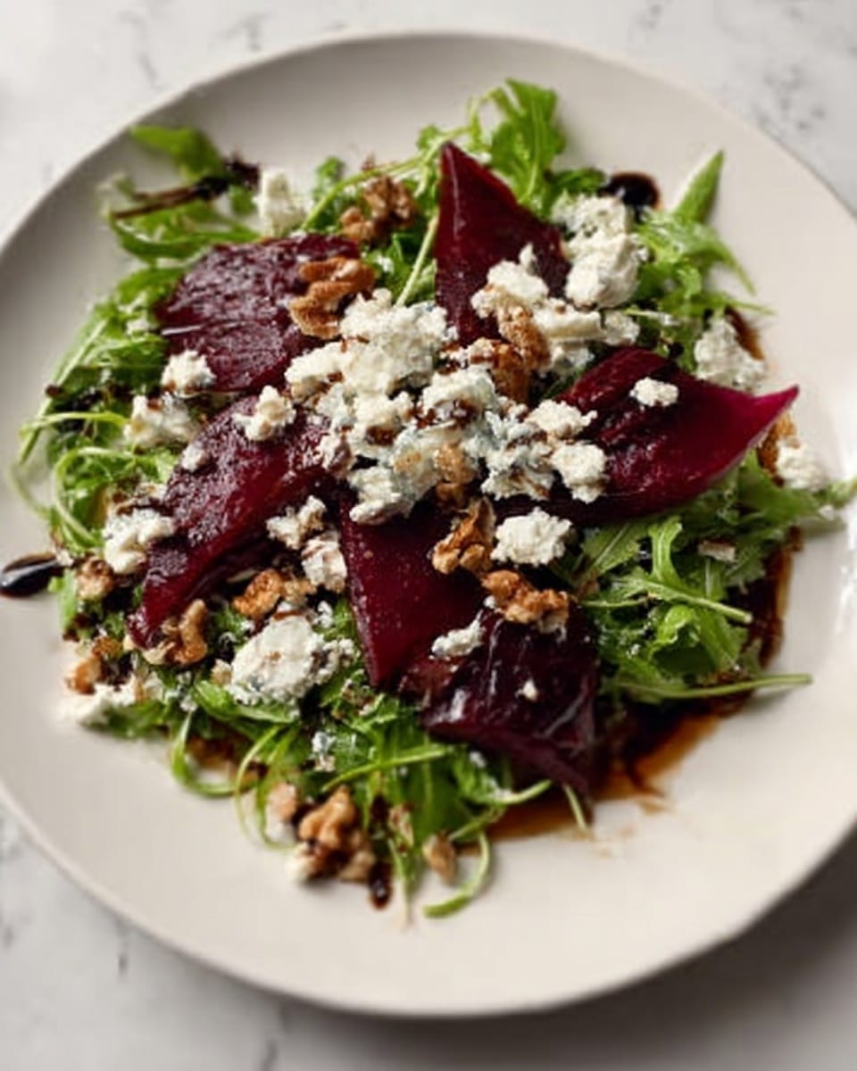 The dish is presented on a white plate with a bed of fresh green arugula leaves forming the base layer. On top of the greens, there are thin slices of deep red, slightly translucent beetroot scattered evenly. Crumbled white cheese is sprinkled generously over the beetroot and greens, adding a textured and soft contrast. Small bits of walnuts are interspersed throughout the salad, providing a crunchy texture. The salad is lightly drizzled with a dark balsamic dressing, pooling subtly around the edges of the plate. The background surface is a white marbled texture, giving a clean and elegant look. Photo taken with an iphone --ar 4:5 --v 7