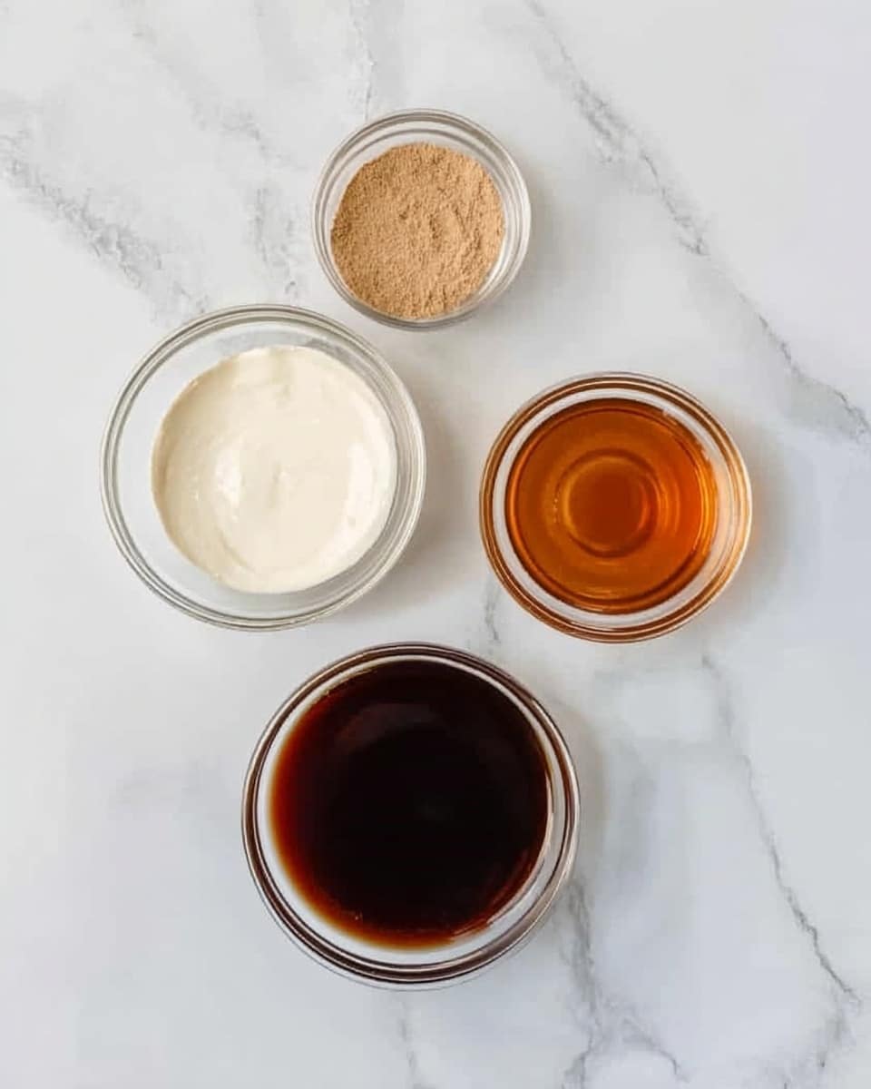 The image shows four clear glass bowls placed on a white marbled surface. The largest bowl at the bottom contains a dark brown liquid. Above it to the left is a medium bowl with a smooth white creamy layer. To the right of the white creamy layer is a small bowl with an amber colored liquid. Above the white creamy layer and amber liquid is the smallest bowl with a light brown powder. The bowls are arranged in a loose square shape. photo taken with an iphone --ar 4:5 --v 7