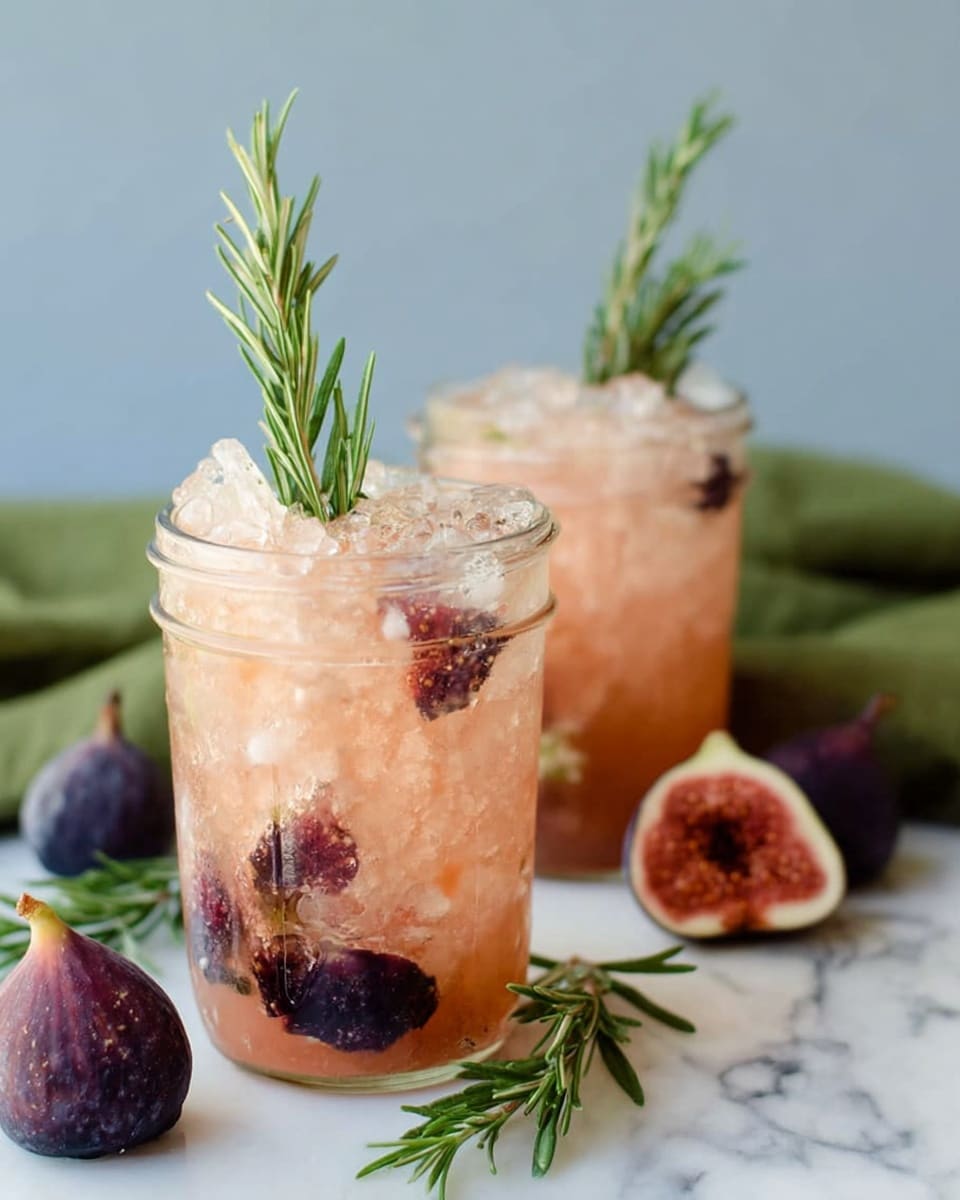 The image shows two clear glass jars filled with a light pinkish-orange drink mixed with crushed ice and dark purple fruit pieces, most likely figs, scattered inside. Each jar is garnished with a single green rosemary sprig standing upright in the middle. The jars sit on a white marbled surface with a green cloth partly visible in the background. In the foreground, there is a fig cut in half showing its red interior, while some whole figs and sprigs of rosemary are casually placed around the jars, adding a fresh and natural look. Photo taken with an iphone --ar 4:5 --v 7