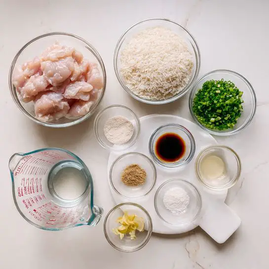 A clear glass bowl on the left holds raw pink chicken slices with a soft texture. Above it, another clear bowl contains white uncooked rice grains. To the right, a small clear bowl has light green chopped spring onions. In front of these, a white round plate holds seven small clear bowls arranged in a loose circle: one with white powder, another with light brown powder, a third with dark brown liquid, one with yellow thin ginger slices, one with a light green chopped herb, one with white salt, and one with a pale yellow liquid. In front, a clear measuring cup holds water and shows red measurements. All the items are placed on a clean white marbled surface. photo taken with an iphone --ar 4:5 --v 7
