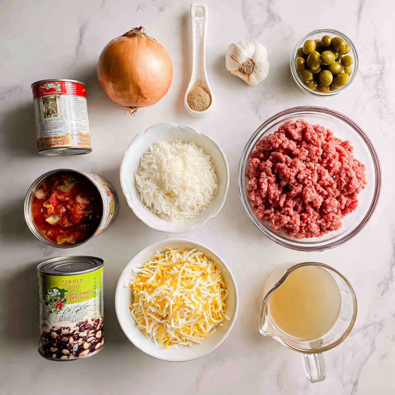 The image shows ingredients for a recipe placed neatly on a white marbled surface. At the top left, there is one whole onion and two garlic cloves. Next to them, a container of light brown spice is placed. Below that, a clear bowl holds raw ground meat with a red color and soft texture. To the left, there is a white measuring spoon filled with white rice. Below the rice, a can of diced tomatoes is visible, showing red and green on the label. Next to it, a can of green chili peppers is placed, with a green and yellow label. At the right edge, a can of black beans is shown, labeled in black and green. In front and below, a clear white bowl holds a mix of shredded cheese in yellow and white colors with a soft and fluffy look. Next to the cheese, a glass measuring cup filled with light brown broth is visible, showing slightly transparent liquid. The whole setup looks clean and organized. photo taken with an iphone --ar 4:5 --v 7