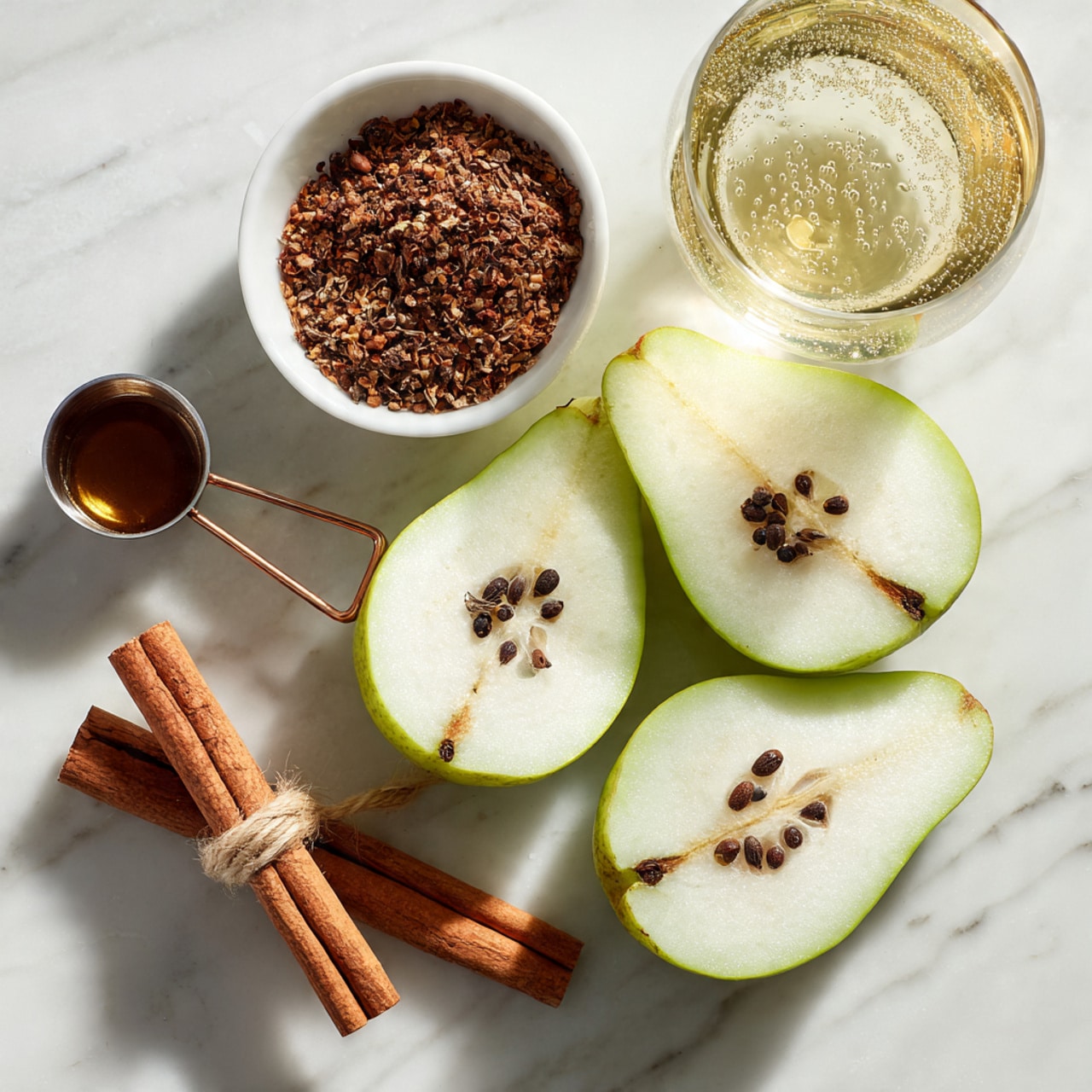 The image shows four halves of a green pear with white flesh and dark seeds, placed on a white marbled surface. To the left of the pears, there is a small metal measuring cup filled with a dark brown liquid. Above the cup, there is a white bowl filled with a mix of brown spices including star anise. To the left of the bowl, there are two cinnamon sticks tied together with a light string. In the top right corner, there is a clear glass with a light yellow bubbly liquid inside. Photo taken with an iphone --ar 4:5 --v 7