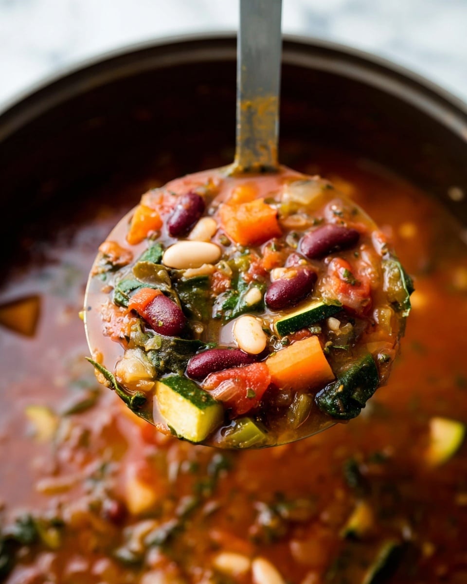 A close-up view of a ladle filled with thick vegetable soup lifted above a pot, showing multiple layers including bright orange chunks of carrot, dark red kidney beans, white large beans, green leafy spinach, and small pieces of zucchini all mixed in a rich reddish-brown broth with visible herbs and spices; the background displays more of the soup with similar colorful ingredients in a thick, hearty texture, all set against a white marbled surface. photo taken with an iphone --ar 4:5 --v 7