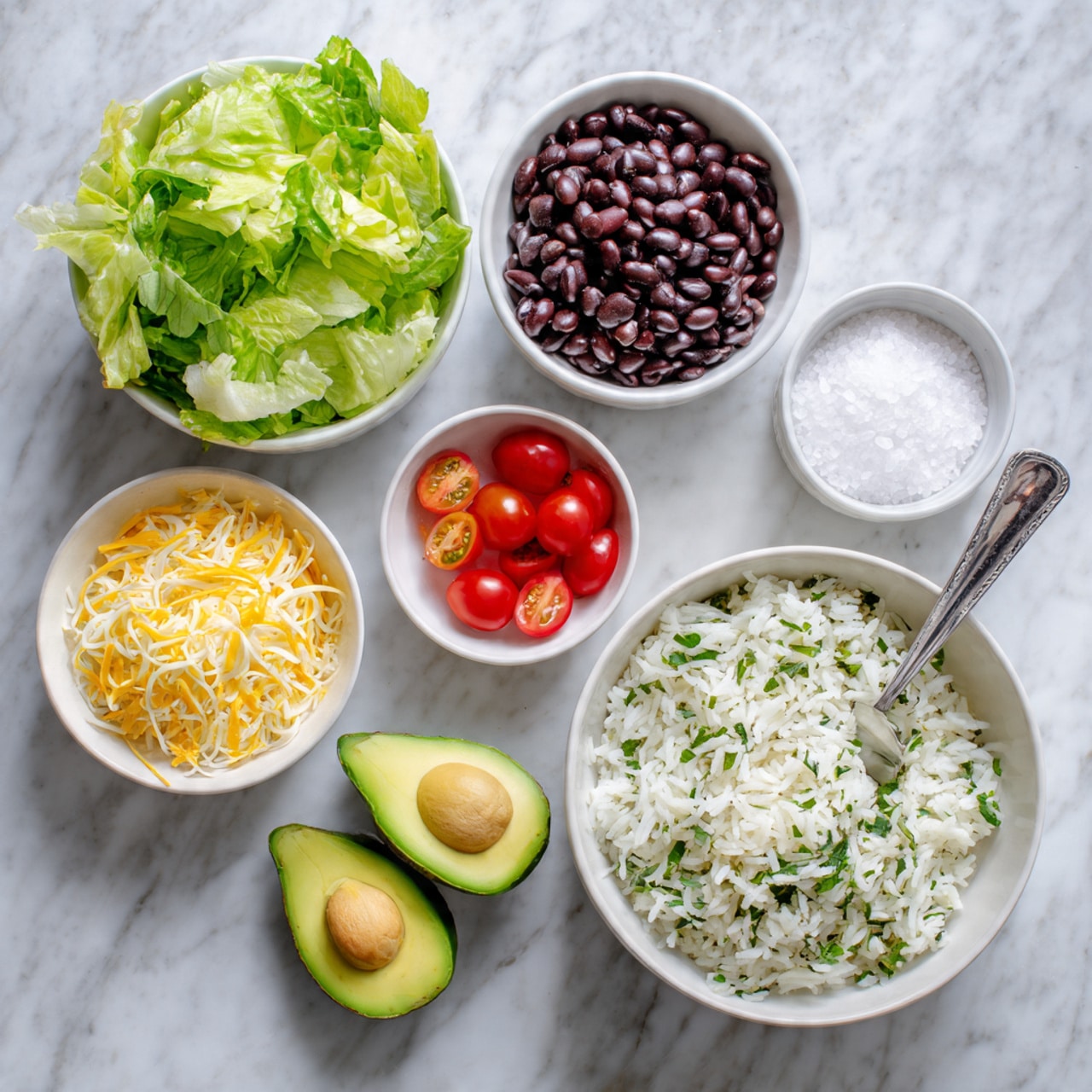 The image shows six white bowls and one white plate on a white marbled surface. The top left white bowl is full of green lettuce leaves. To its right, a white bowl is filled with black beans. Below the lettuce, there is a small white bowl of white salt crystals. In the middle, a small white bowl contains shiny red cherry tomato halves. To the right of the tomatoes, two halves of a green avocado are placed on the marble surface. Below the salt, another small white bowl holds shredded yellow cheese. At the bottom right, a large white bowl is filled with white rice mixed with green herbs, with a silver spoon resting inside. Photo taken with an iphone --ar 4:5 --v 7