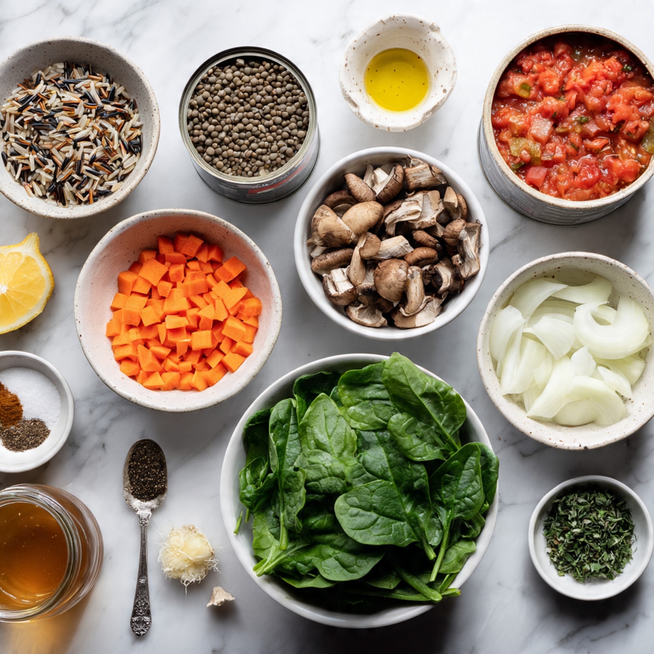 The image shows various cooking ingredients neatly placed on a white marbled surface. Starting from the top left, there is a small bowl filled with mixed wild rice, next to it is a bowl of dry lentils, and beside that, an open can of diced tomatoes. Below the lentils is a bowl of chopped brown mushrooms. To the right of the mushrooms is a large white bowl full of fresh green spinach leaves. Below the mushrooms and to the left of the spinach is a bowl containing finely diced orange carrots and pale green celery. Next, there is a small white bowl containing different spices — a mix of black pepper, salt, and some brown and red spices. Below this bowl, on the right side, is a spoon filled with minced garlic and a tiny bowl with chopped green herbs. On the lower left side, there is a white bowl filled with chopped white onions. Beside the onions, there is a glass jar of water, beside that a lemon, and near the bottom left corner, a jar containing a brown liquid that looks like broth or sauce. There is also a small white bowl with yellow oil near the onions. The photo shows all items arranged carefully for easy viewing, and the photo is taken with an iphone --ar 4:5 --v 7