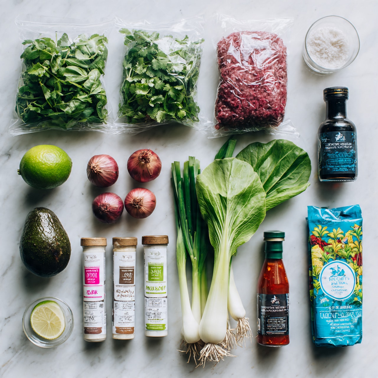 The image shows a white marbled surface with fresh cooking ingredients arranged neatly. On the top left, there are two transparent packets of fresh herbs labeled coriander and Thai basil, both with bright green leaves. Below them, a ripe avocado sits next to a green lime. Near the center, a clear plastic tray holds minced red meat with white fat mixed in. To the right of the meat, there are two bottles: one with orange sweet chili dipping sauce and another with black soy sauce. On the bottom center, there are two small jars and tubes of paste and spice. Towards the top right, fresh green lettuce and spring onions lie next to a small white bowl of salt and another bowl with dark pepper. A fresh white garlic bulb and two small shallots complete the group, with a package of spring roll wrappers visible beneath some of the ingredients. The overall look is clean and fresh, ready for cooking photo taken with an iphone --ar 4:5 --v 7