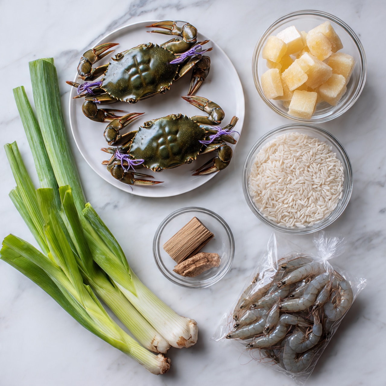 Two shiny dark green crabs tied with purple string sit side by side on a white plate on the top left. To their right, a clear glass bowl holds pale yellow dried cubes and a small piece of light brown root. Below that bowl, another clear round container is filled with short white rice grains. At the bottom right, a transparent bag full of raw grayish shrimps lies flat. On the bottom left, a bunch of fresh green onions and celery with long green stalks and roots with some purple tint are placed diagonally. The whole scene is set on a white marbled surface. Photo taken with an iphone --ar 4:5 --v 7