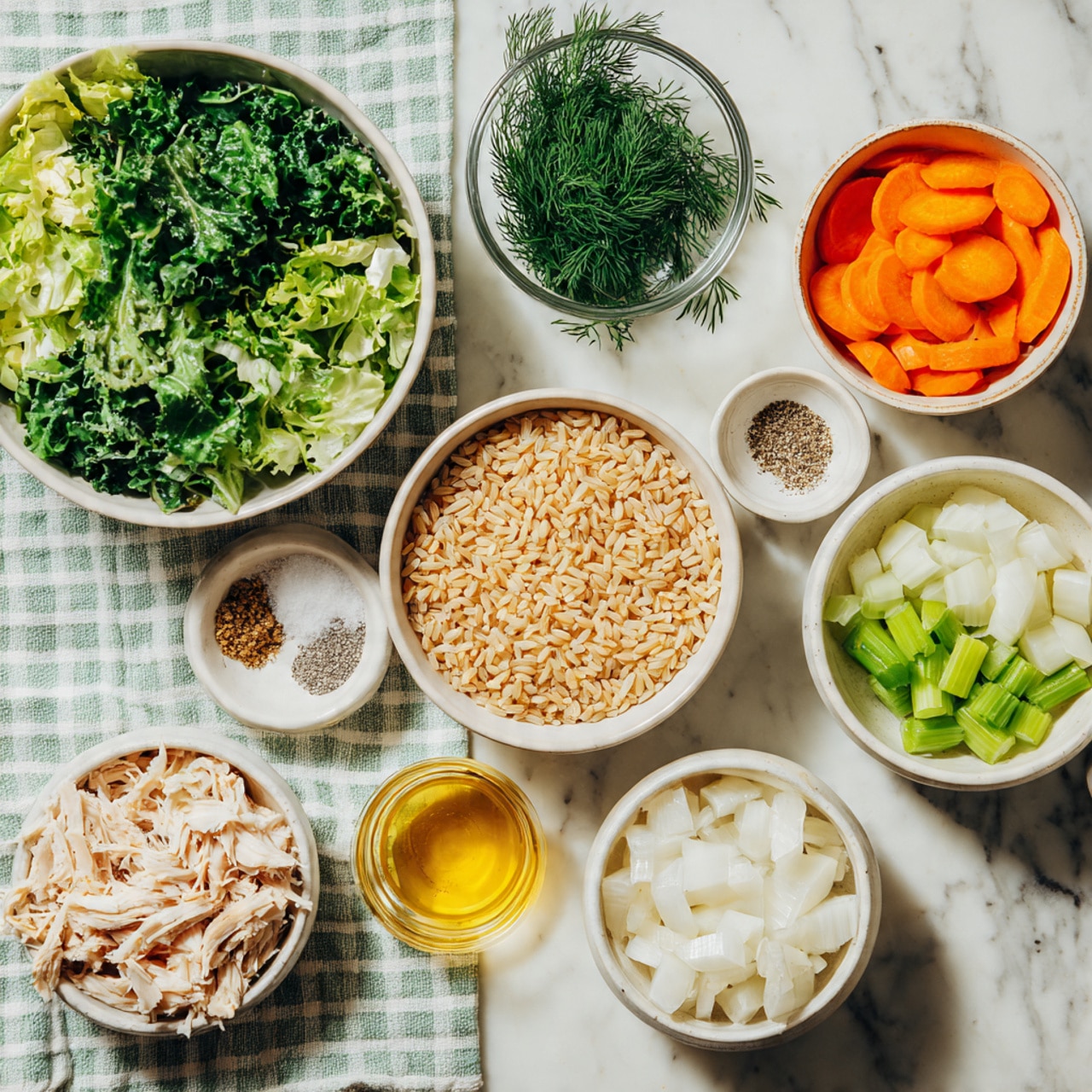 The image shows nine white bowls and small cups arranged on a white marbled surface with a light green and white checkered cloth running underneath them. Starting from the top left, there is a large white bowl filled with chopped green leafy vegetables. To its right, a small glass bowl holds fresh dill. Next to that, a medium white bowl contains round slices of bright orange carrots. To the right side, a medium white bowl is filled with uncooked brown rice grains. Below the rice, there is a small clear bowl showing two seasonings: salt and ground black pepper, side by side. Next to that, a small clear cup has a golden yellow liquid, likely olive oil. Below the large bowl with leaves, there is a large white bowl filled with shredded pale cooked chicken. Below that, a small white bowl contains chopped white onions. Lastly, towards the right bottom, another medium white bowl holds small pieces of chopped green celery. All ingredients are neatly organized, showing a fresh and colorful feel. Photo taken with an iphone --ar 4:5 --v 7