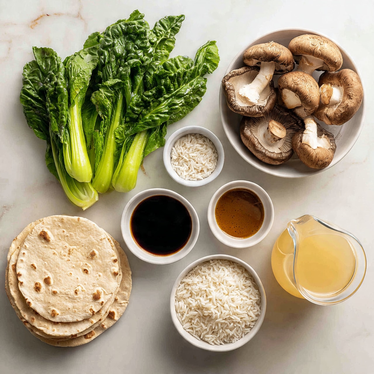 The image shows different ingredients placed on a white marbled surface. On the upper left, there are fresh green leafy vegetables with light green stalks. To the right, there is a white bowl filled with large brown mushrooms, some whole and some sliced. Next to the mushrooms, there is a stack of light beige flatbreads. Below the vegetables, a white bowl is filled with white rice grains. In the middle, a small white bowl holds a dark brown sauce. On the bottom right, a large clear glass jug is filled with light yellow broth or liquid. Another smaller white bowl below this jug also contains white rice grains. The colors are natural and fresh, with each bowl clearly separated. photo taken with an iphone --ar 4:5 --v 7