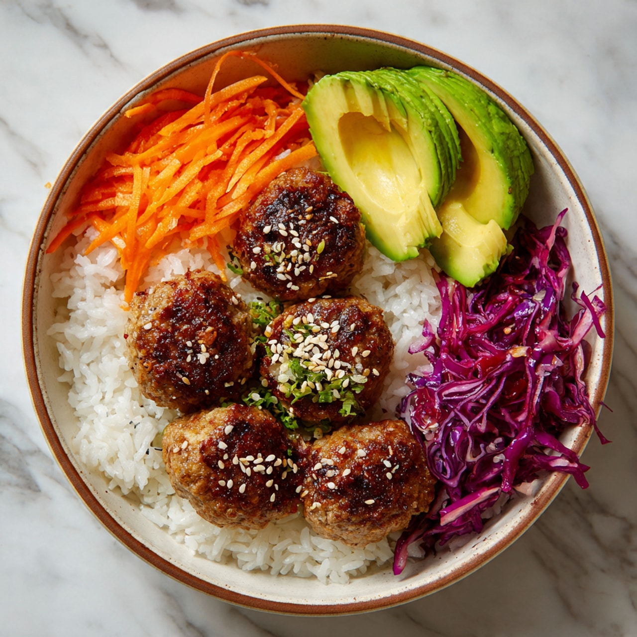 A round bowl filled with a layer of white rice at the bottom, topped with five golden-brown meatballs sprinkled with sesame seeds in the center. On one side, there are thin carrot strips in bright orange, and next to them shredded purple cabbage. On the opposite side of the meatballs, there are two avocado halves with smooth, green flesh and brown seeds. Light steam rises from the dish, showing it is hot. The bowl sits on a white marbled surface. Photo taken with an iphone --ar 4:5 --v 7