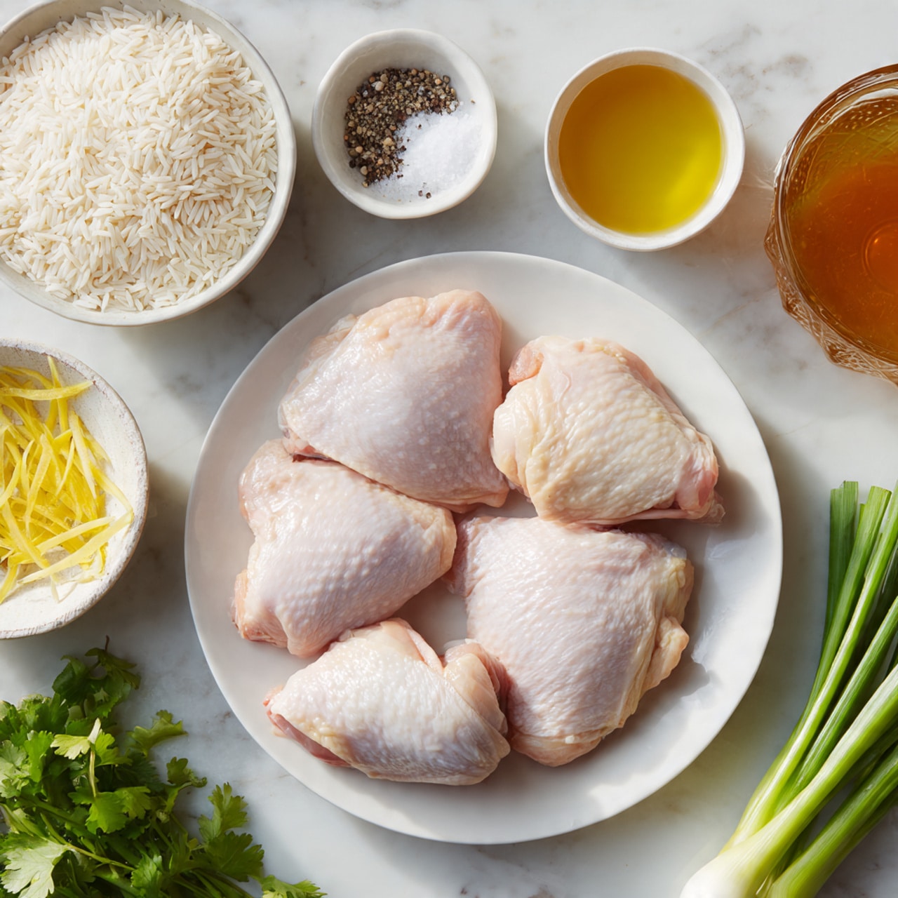 The image shows a white round plate in the center with four raw chicken thighs, pale pink with a smooth skin layer. Around the plate, several small white bowls hold different ingredients: one bowl of short white rice grains, one with thin yellow strips of ginger, one with a golden-yellow liquid, and a small bowl with a brownish sauce. A few green onions are placed on the right side, while fresh green cilantro leaves are on the bottom left. There are also two small round bowls near the bottom containing white salt crystals and ground black pepper. A large glass container with amber chicken broth is partially visible at the bottom right. The background is a white marbled texture. photo taken with an iphone --ar 4:5 --v 7