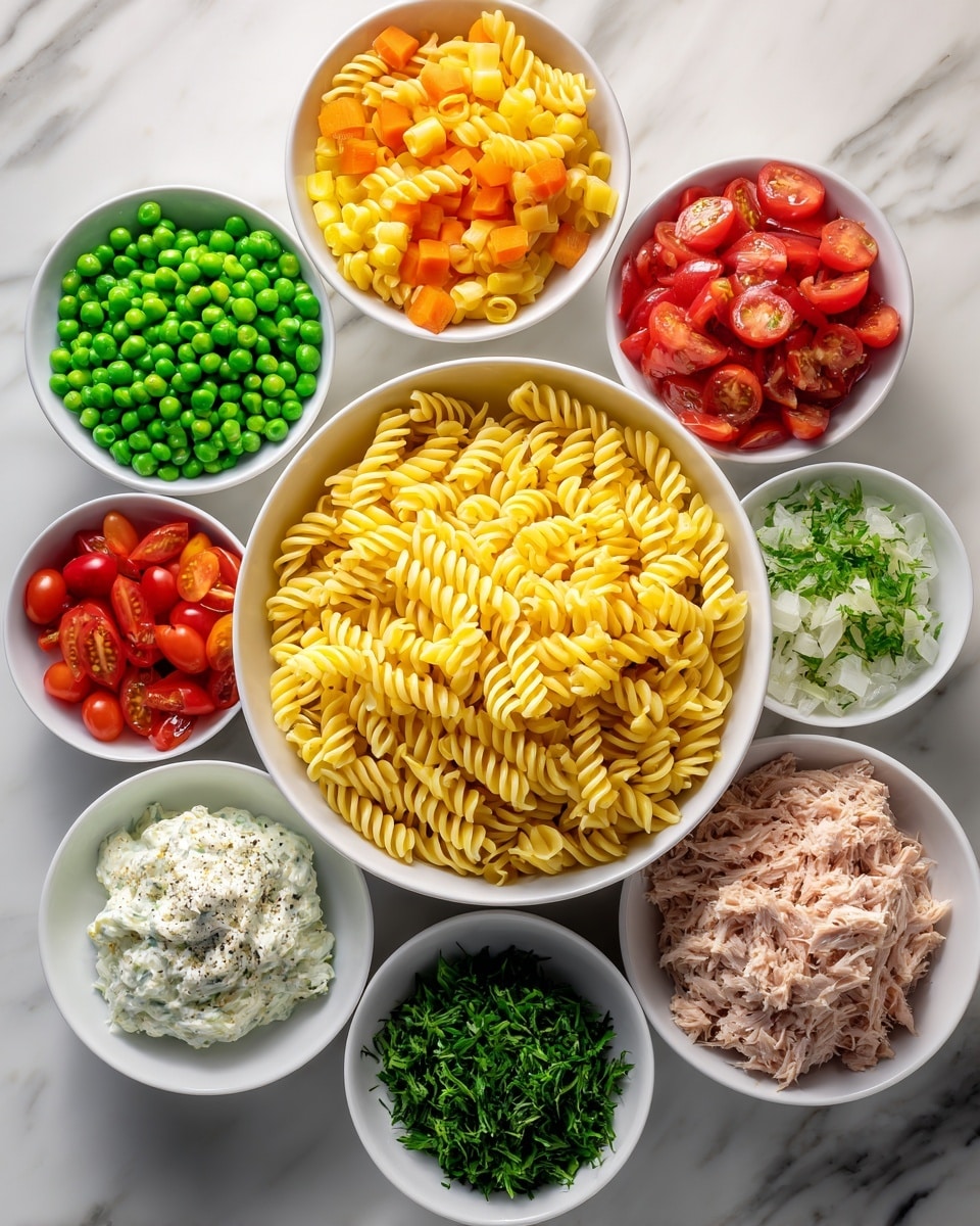 The image shows several white bowls arranged in a circle on a white marbled surface, each bowl containing different colorful ingredients. In the center is a larger bowl filled with yellow spiral pasta. Surrounding it are smaller bowls with bright green peas, chopped green celery, diced orange carrots, red grape tomatoes cut in halves, shredded light beige tuna, a white creamy sauce, minced garlic, creamy dressing, black pepper, and finely chopped herbs. Each bowl clearly shows the texture of the ingredient inside, creating a vibrant and fresh look photo taken with an iphone --ar 4:5 --v 7
