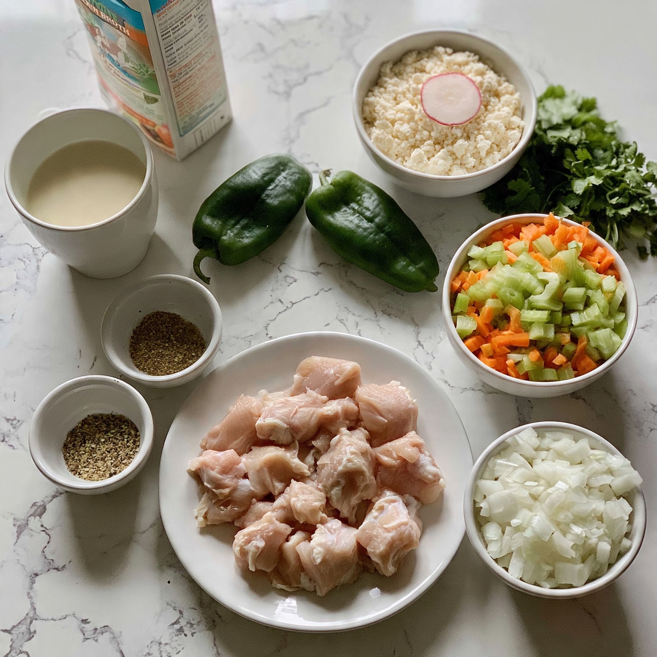 square image The image shows a clean kitchen counter with a white marbled texture background holding various ingredients for cooking. In the center, there is a white plate with raw chicken pieces arranged neatly. Surrounding the plate, there is a small white bowl with a mix of dry spices, a white bowl filled with diced onions, and a white bowl with finely chopped celery and carrots. To the upper right, a white bowl holds cotija cheese with a radish slice on top, next to some fresh cilantro. Two whole green poblano peppers are placed side by side near the center. On the left, there is a white cup filled with a creamy liquid and a carton of chicken broth standing beside it. The setup shows a calm and organized preparation scene. Photo taken with an iphone --ar 4:5 --v 7