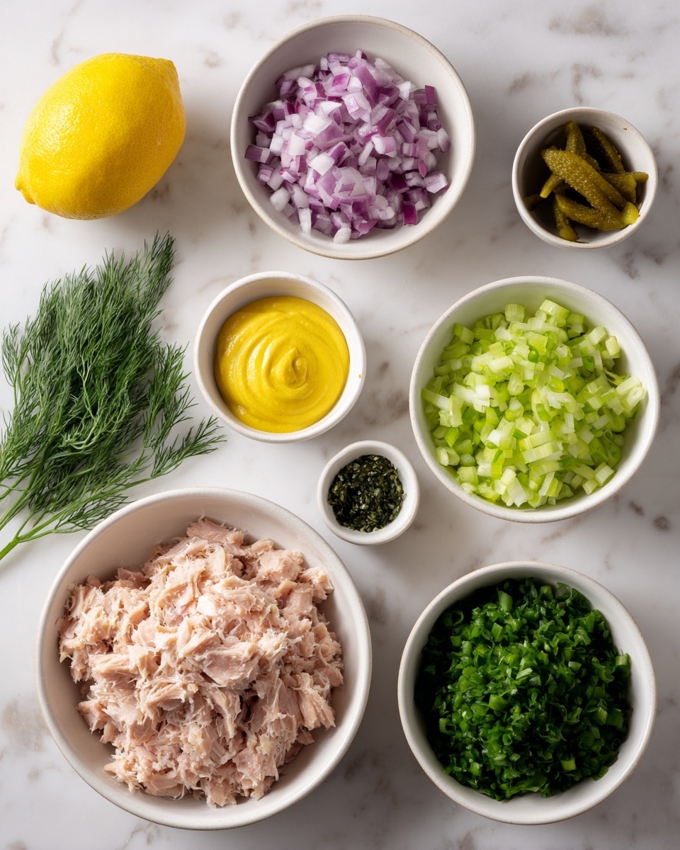 Several bowls and a lemon are on a white marbled surface. In the bottom left, a white bowl is full of shredded, light pink tuna. Above it to the left, there is a white bowl with finely chopped purple and white onions. Near the center, a small bowl holds bright yellow mustard sauce. To its right, there is a bowl filled with chopped dark green onions. Below that, a larger bowl contains finely chopped light green celery. A small bowl with chopped green pickles is near the center bottom. At the top, a tiny bowl holds sprigs of fresh green dill. A whole yellow lemon is in the bottom left corner. Photo taken with an iphone --ar 4:5 --v 7