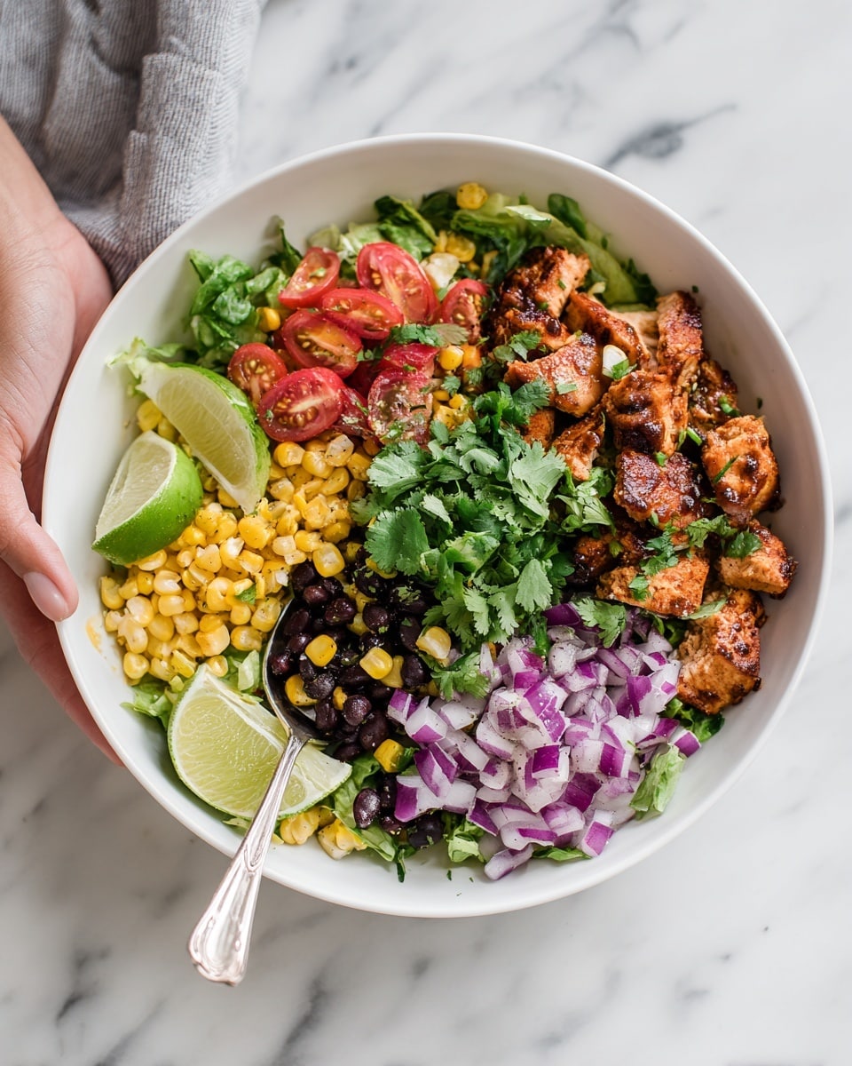A white bowl filled with a colorful salad sits on a white marbled surface. The salad layers include golden roasted corn kernels as the base, mixed with small cubes of purple onions, bright red cherry tomato halves, and small black beans scattered throughout. There are also pieces of light brown grilled chicken mixed in, topped with fresh green cilantro leaves. On the side of the bowl are lime halves, and a woman's hand holding a small silver spoon is just visible in the corner. photo taken with an iphone --ar 4:5 --v 7
