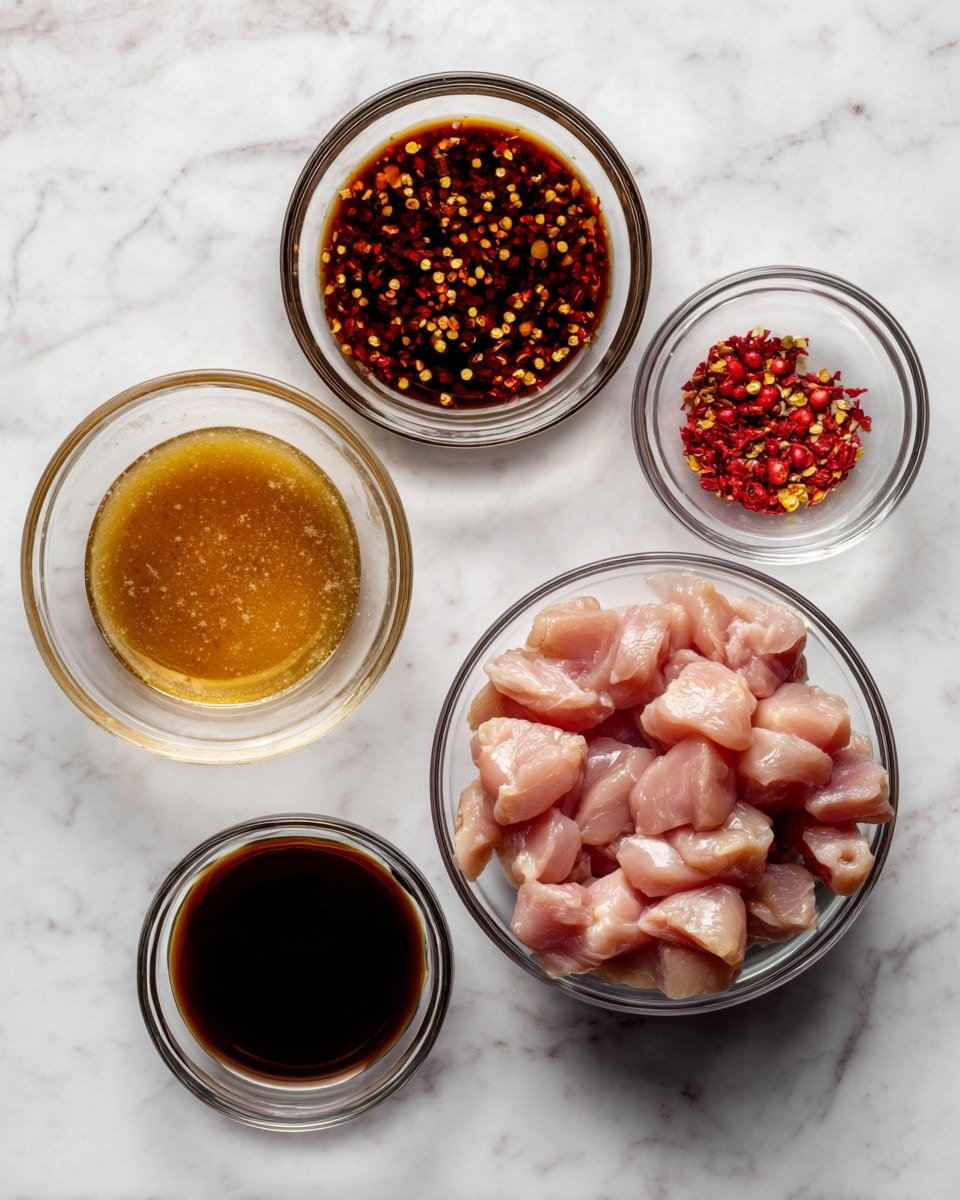 The image shows five glass bowls placed on a white marbled surface. The largest bowl at the bottom right contains raw chicken pieces, light pink in color and cut into small chunks with a smooth texture. To the left of this bowl is a smaller one filled with a honey-colored liquid, smooth and slightly thick. Above that is a bigger bowl with a dark brown liquid scattered with small red chili flakes floating on the surface. To the right of the chili bowl is a smaller bowl filled with a very dark brown liquid, almost black and smooth in texture. Above the dark liquid bowl is the smallest bowl with a small amount of red chili flakes, showing a mix of red and yellow colors. photo taken with an iphone --ar 4:5 --v 7