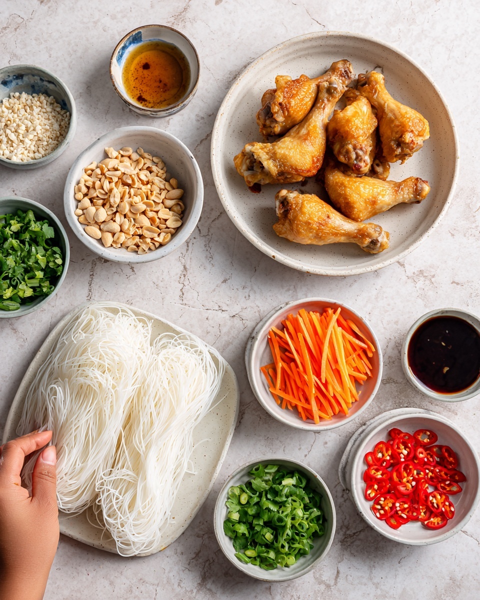 The image shows several small white bowls arranged neatly on a white marbled surface. One large white plate holds four cooked chicken drumsticks with a golden brown color and slightly crispy texture. Nearby, a square white plate has a stack of uncooked rice noodles with a pale cream color and thin strands. The small bowls contain different colorful ingredients: thin orange carrot sticks, bright green chopped cilantro, light brown crushed peanuts, red sliced chili, dark brown sauce, light golden liquid, finely chopped green onions, white sesame seeds, and a small amount of a reddish sauce. A woman's hand is placing or holding one of the bowls. The scene looks clean and ready for cooking. photo taken with an iphone --ar 4:5 --v 7