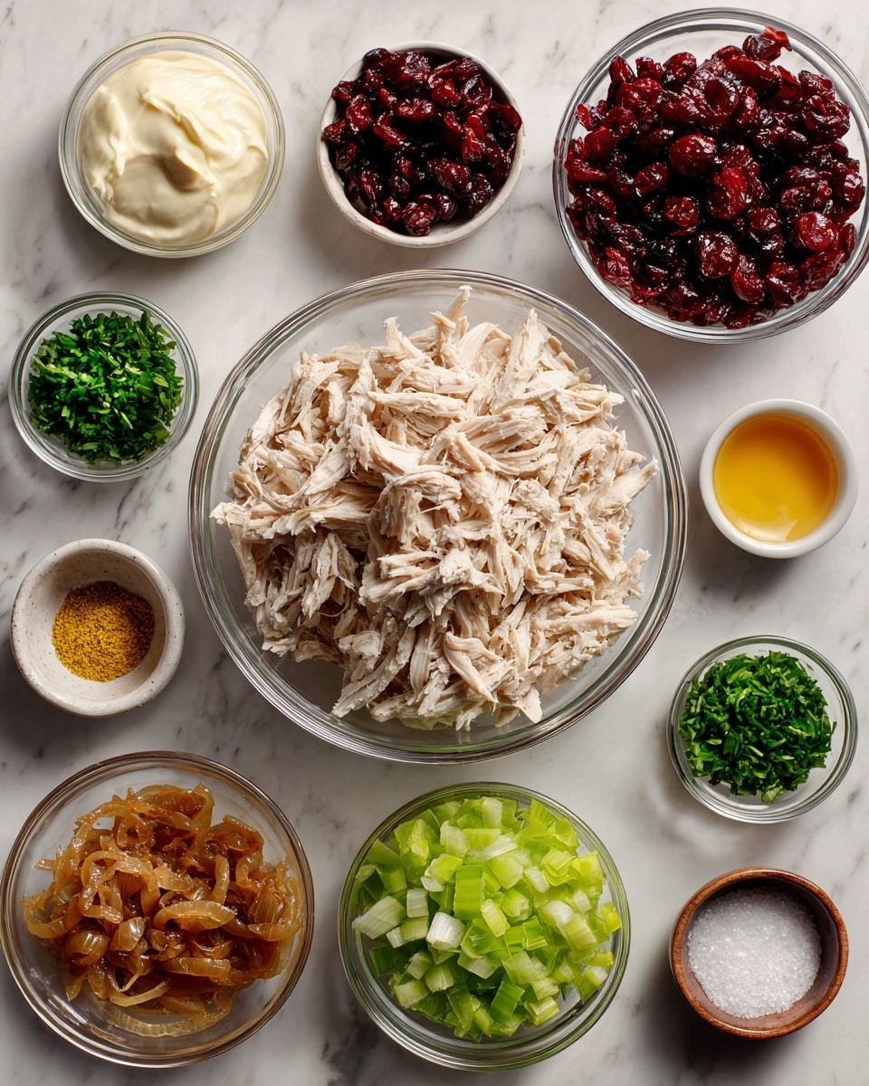 The image shows various ingredients in clear glass bowls arranged neatly on a white marbled surface. The largest bowl, placed near the center, contains shredded light beige cooked chicken. Surrounding it are smaller bowls with different contents: finely chopped bright green celery on the right, creamy white mayo at the top left, deep red dried cranberries next to the mayo, finely chopped dark green parsley below the cranberries, minced fresh chives on the far left, golden mustard in a small bowl near the bottom center, golden-brown caramelized onion next to the mustard, and a bowl of coarse white salt and a few grains of black pepper near the bottom left corner. A woman’s hand is not visible here. photo taken with an iphone --ar 4:5 --v 7