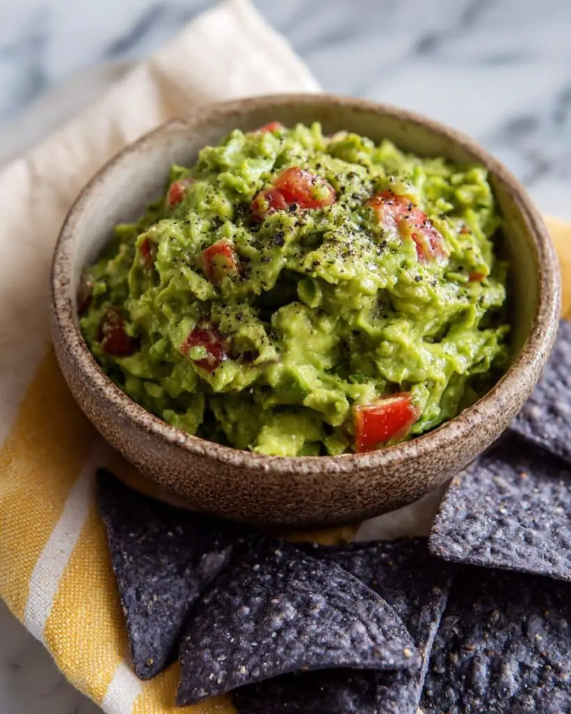 Creamy Homemade Guacamole with Fresh Tomatoes, Lime, and Cilantro Recipe