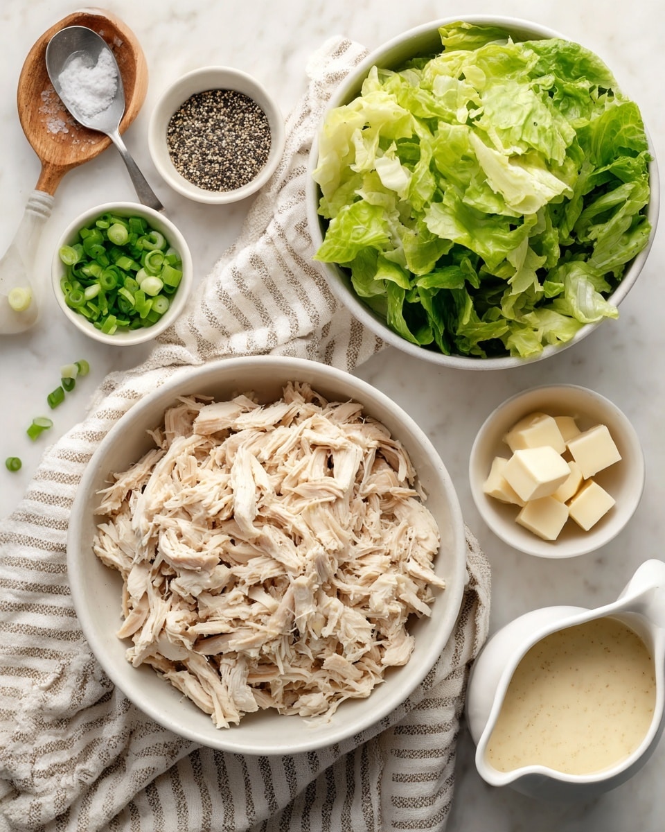 The image shows a white bowl full of shredded chicken as the main layer, placed on a beige striped cloth on top of a white marbled surface; near it is a white bowl filled with fresh green lettuce leaves, another small white bowl with sliced green onions, and white measuring spoons holding cubes of butter along with a mix of black and white seasoning seeds; a small white pitcher with a creamy light sauce is also included, arranged neatly in the scene. photo taken with an iphone --ar 4:5 --v 7