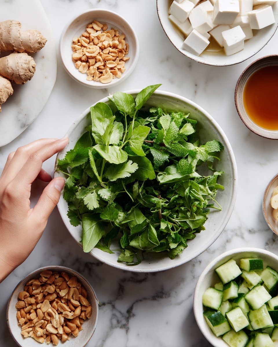 A white bowl filled with fresh green herbs including cilantro and leafy greens is centered. To the left of it are three small white bowls, one with chopped ginger, one with peanuts, and one with a brown liquid. To the right, two white bowls hold cubed tofu in water and diced cucumber in water. The background is a white marbled surface. A woman's hand is reaching in from the left side near the ginger bowl. Photo taken with an iphone --ar 4:5 --v 7