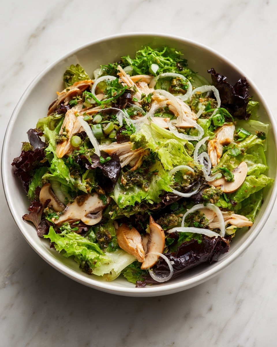 A white bowl filled with a fresh salad consisting of several layers: the base layer is a mix of green and dark purple leafy lettuce, topped with thin strips of light beige mushrooms spread evenly. There are scattered small pieces of chopped pale green herbs, and on top, thin pale rings of onion rest, adding texture and contrast. The salad looks crisp and fresh, with a light dressing that makes the ingredients look a bit shiny. The bowl sits on a white marbled surface. Photo taken with an iphone --ar 4:5 --v 7