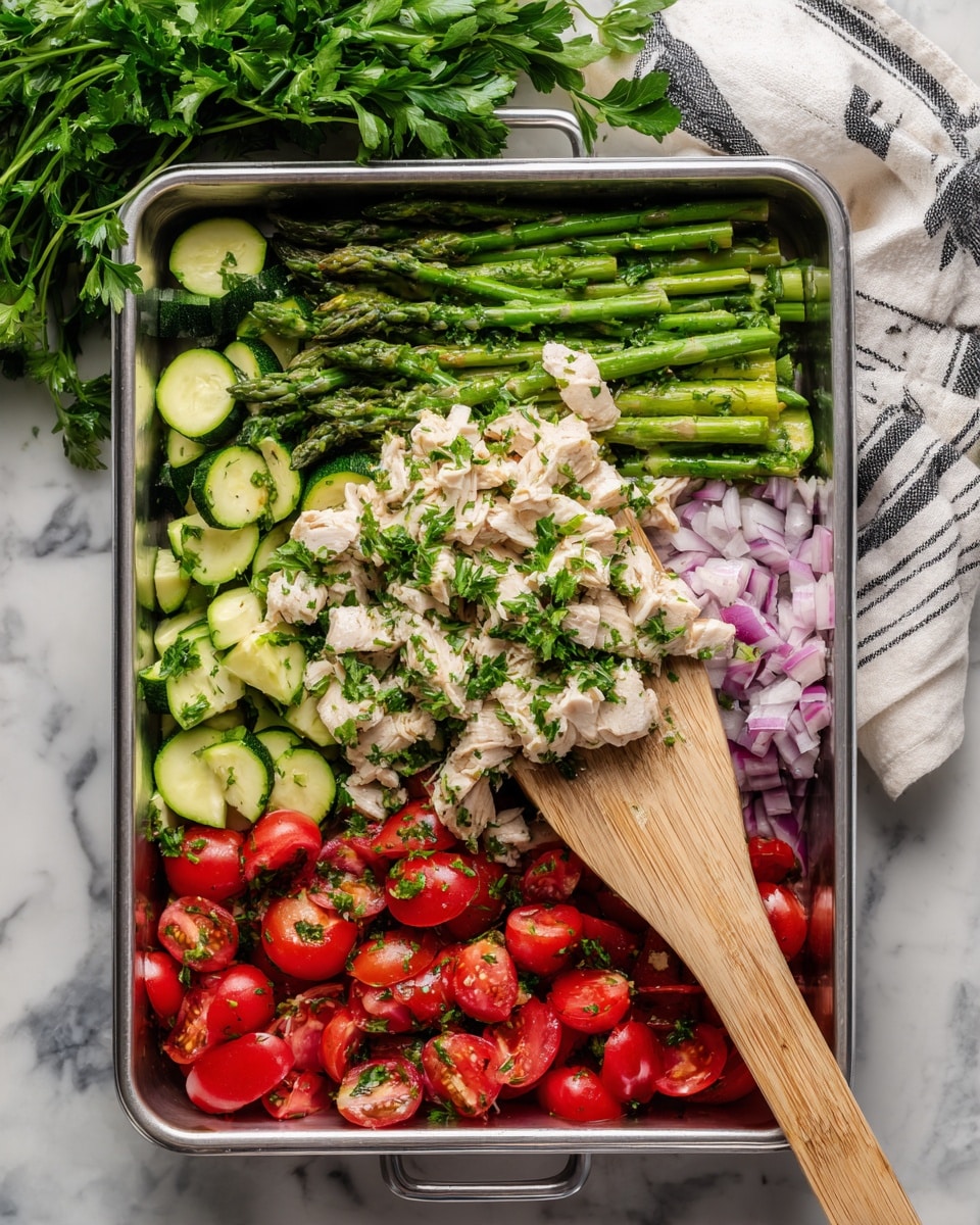A metal tray filled with three layers of food: the bottom layer has sliced green zucchini and chopped red onion, the middle layer has bright green asparagus and halved red cherry tomatoes, and the top layer has small white pieces of cooked chicken sprinkled with chopped green parsley. A wooden spatula is lifting some of the mixture from the lower right corner. The tray is set on a white marbled surface with a bunch of fresh green parsley on the top left and a white cloth with black stripes draped on the top right. Photo taken with an iphone --ar 4:5 --v 7