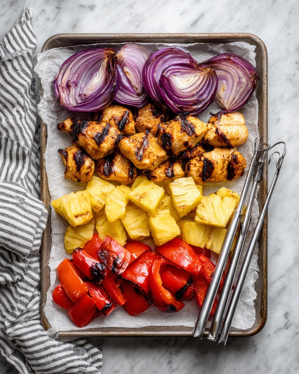 The image shows a baking tray lined with white parchment paper on a white marbled surface. On the tray, there are four groups of grilled food items arranged in rows from top to bottom: the top row has pieces of grilled red onion with visible char marks and purple skin; below it are golden-brown grilled chicken chunks with light char spots; next is a cluster of bright yellow grilled pineapple pieces with small grill marks; and at the bottom, there are vibrant red grilled bell pepper pieces with blackened edges. Four metal skewers rest diagonally on the right side of the tray, and a striped cloth napkin is partially visible at the bottom left corner. photo taken with an iphone --ar 4:5 --v 7