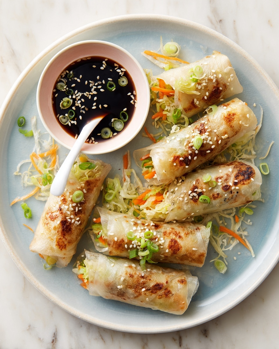 On a white plate with a light blue inner surface, there are six browned, grilled spring rolls arranged mostly in the center and right side, showing a slightly crispy texture with visible cooked vegetables like orange carrot strips and green scallions inside translucent rice wrappers. Small toasted white sesame seeds and chopped green scallions are sprinkled over the rolls and plate. To the left side, a small white bowl with a pink outside holds dark soy dipping sauce with floating sesame seeds and sliced green scallions, and a white ceramic spoon rests inside the bowl. The plate is set on a white marbled surface photo taken with an iphone --ar 4:5 --v 7